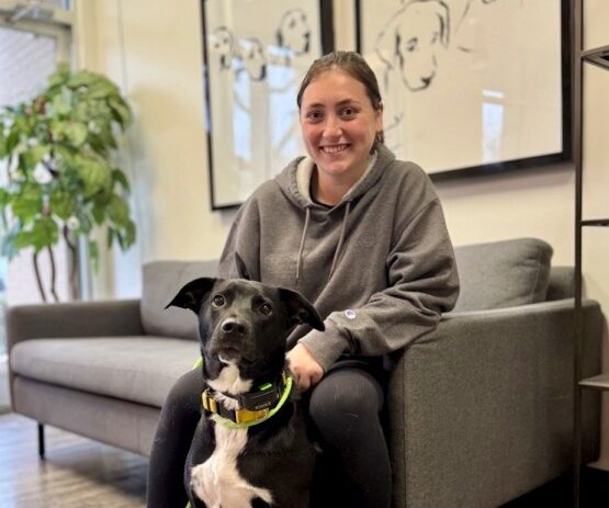 All-Star Dog Training member sitting on couch with dog