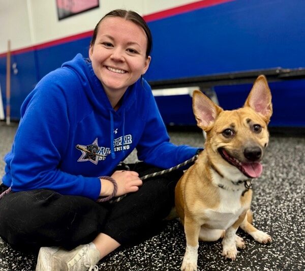dog and trainer sitting and smiling for the camera